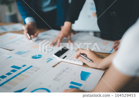 Accountant checking financial statement or counting by calculator income for tax form, Business woman sitting and working with colleague discussing the desk in office. Audit concept. 104529453