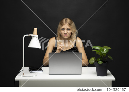 Frustrated sad woman feeling tired worried about problem sitting in office with laptop. Stressed depressed girl troubled with reading bad news online. 104529467