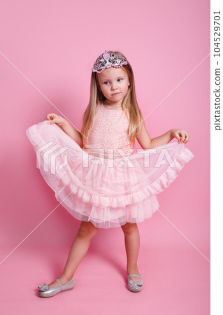 Little cute kid girl birthday princess 5-6 years old wears pink dress crown diadem posing on pink background Little cute kid girl birthday princess 5-6 years old wears pink dress crown diadem posing on pink background 104529701