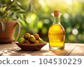 Amla oil in a transparent bottle on wooden table with raw Indian gooseberry fruit in a basket, sunny garden background. 104530229