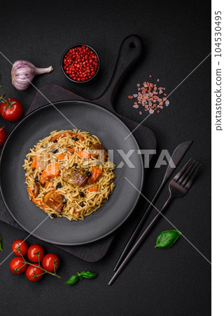 Delicious fresh pilaf with rice, carrots, meat, onions, spices and berries 104530495