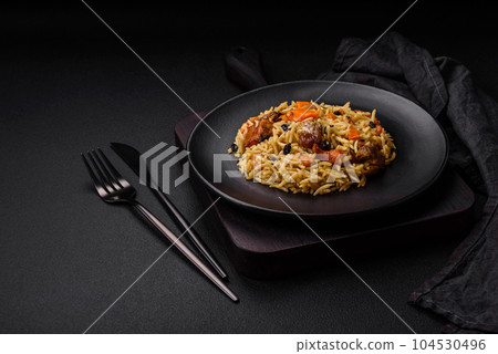 Delicious fresh pilaf with rice, carrots, meat, onions, spices and berries 104530496