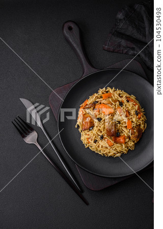 Delicious fresh pilaf with rice, carrots, meat, onions, spices and berries 104530498