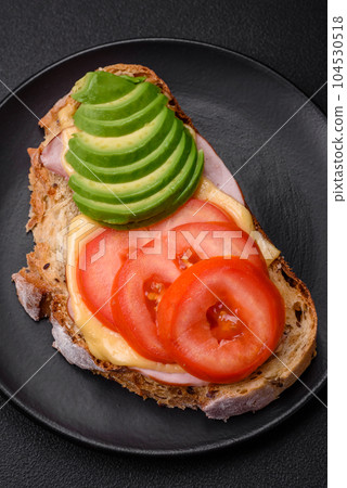 Delicious nutritious grilled toast with ham, cheese, tomatoes and avocado Delicious nutritious grilled toast with ham, cheese, tomatoes and avocado 104530518