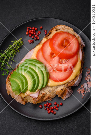 Delicious nutritious grilled toast with ham, cheese, tomatoes and avocado Delicious nutritious grilled toast with ham, cheese, tomatoes and avocado 104530531