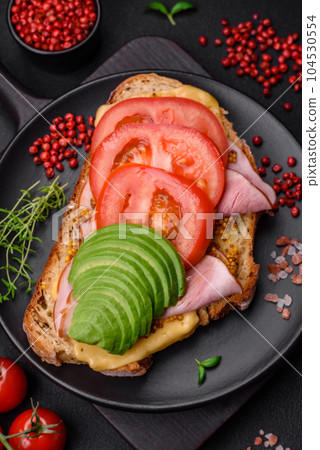 Delicious nutritious grilled toast with ham, cheese, tomatoes and avocado Delicious nutritious grilled toast with ham, cheese, tomatoes and avocado 104530554