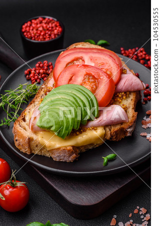 Delicious nutritious grilled toast with ham, cheese, tomatoes and avocado Delicious nutritious grilled toast with ham, cheese, tomatoes and avocado 104530555