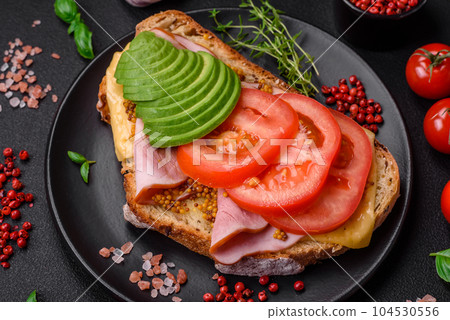 Delicious nutritious grilled toast with ham, cheese, tomatoes and avocado Delicious nutritious grilled toast with ham, cheese, tomatoes and avocado 104530556