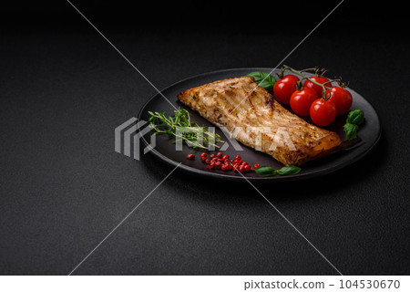 Slice of delicious baked fish with salt, spices and herbs on a ceramic plate Slice of delicious baked fish with salt, spices and herbs on a ceramic plate 104530670