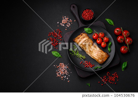 Slice of delicious baked fish with salt, spices and herbs on a ceramic plate Slice of delicious baked fish with salt, spices and herbs on a ceramic plate 104530676