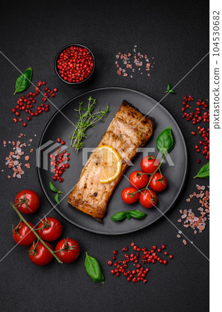 Slice of delicious baked fish with salt, spices and herbs on a ceramic plate Slice of delicious baked fish with salt, spices and herbs on a ceramic plate 104530682