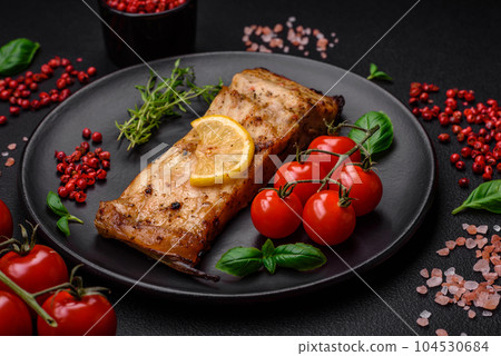 Slice of delicious baked fish with salt, spices and herbs on a ceramic plate Slice of delicious baked fish with salt, spices and herbs on a ceramic plate 104530684