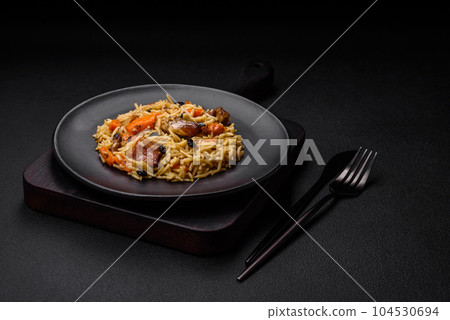 Delicious fresh pilaf with rice, carrots, meat, onions, spices and berries Delicious fresh pilaf with rice, carrots, meat, onions, spices and berries 104530694