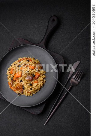 Delicious fresh pilaf with rice, carrots, meat, onions, spices and berries Delicious fresh pilaf with rice, carrots, meat, onions, spices and berries 104530698