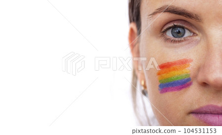 Portrait of a young smiling woman with LGBT flag painted on her cheek Portrait of a young smiling woman with LGBT flag painted on her cheek 104531153