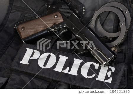 Police handgun with handcuffs on black uniform 104531825