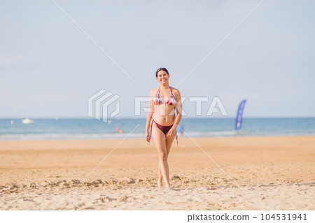 Summer holidays relax and wellbeing. Bikini body positivity Hispanic mid woman at beach. Asturias Summer holidays relax and wellbeing. Bikini body positivity Hispanic mid woman at beach. Asturias 104531941