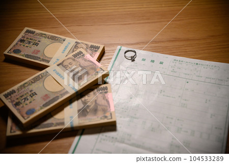 並排排列的離婚文件和一疊錢，贍養費，財產分割，子女撫養費 104533289