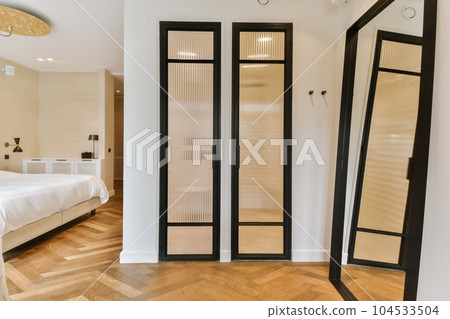 a hotel room with a bed, mirror and two mirrors on the wall in it's corner to the left a hotel room with a bed, mirror and two mirrors on the wall in it's corner to the left 104533504