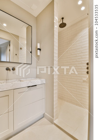 a modern bathroom with white cabinets and marble counter tops on the vanity, along with a walk - in shower 104533535