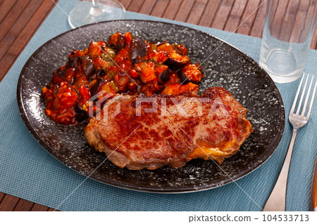 Grilled veal steak with braised vegetables 104533713