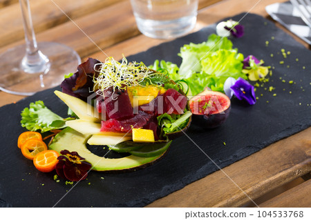 Deliciously salad of raw tuna with avocado, mango and greens at plate Deliciously salad of raw tuna with avocado, mango and greens at plate 104533768