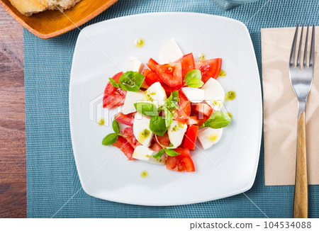 Caprese salad with fresh tomatoes, mozzarella cheese and basilic herb Caprese salad with fresh tomatoes, mozzarella cheese and basilic herb 104534088