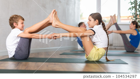 Brother and sister pair doing yoga in gym Brother and sister pair doing yoga in gym 104534297