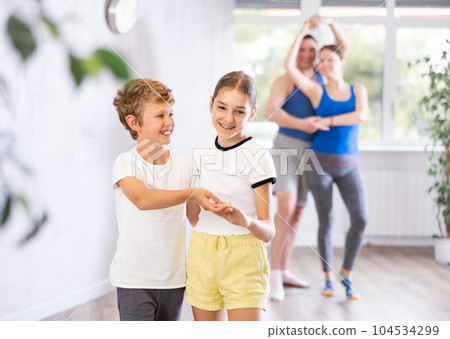 Boy and girl dancing salsa in studio during group training 104534299