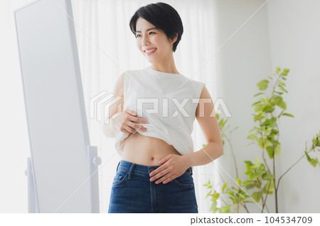 女人在鏡子裡檢查她的肚子 104534709