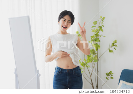 女人在鏡子裡檢查她的肚子 104534713