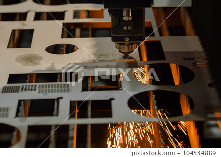 Laser cutting machine working with sheet metal with sparks Laser cutting machine working with sheet metal with sparks 104534889