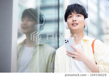 Young man listening to music with headphones Young man listening to music with headphones 104536029