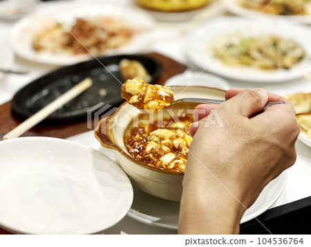 Hands separating mapo tofu 104536764