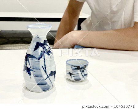 桌上有清酒瓶和清酒杯的男人 104536771