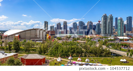 Calgary, Alberta, Canada. Jun 20, 2023. Calgary Downtown skyline during summer and Indigenous tipi's on display in the Indian Village with the dow 104537712
