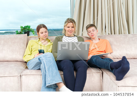 Happy Family on couch using gadget. Rest at home. Using Digital devices at home 104537854