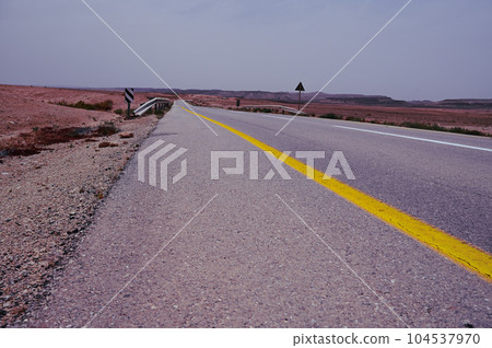 Asphalt road and Negev desert landscape in Israel. 104537970