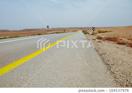Asphalt road and Negev desert landscape in Israel. Asphalt road and Negev desert landscape in Israel. 104537976