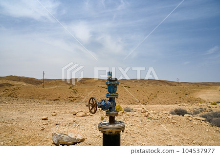 blue color industrial pipe with valve in the desert, water supply system in the desert Negev. blue color industrial pipe with valve in the desert, water supply system in the desert Negev. 104537977