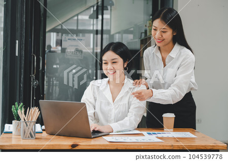 Business woman talking to her colleague during a meeting in a boardroom, Business team working on laptop computer. Business woman talking to her colleague during a meeting in a boardroom, Business team working on laptop computer. 104539778
