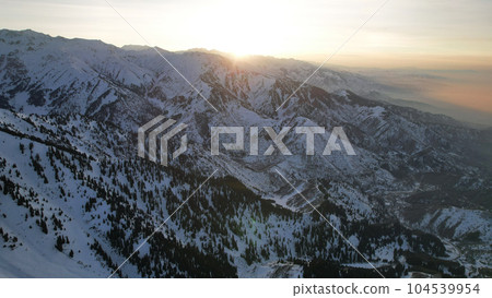 Epic red-orange sunset in high snowy mountains Epic red-orange sunset in high snowy mountains 104539954