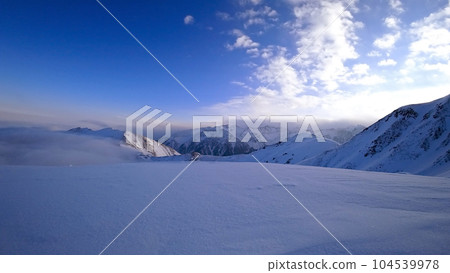 Ocean of clouds in snowy mountains at dawn Ocean of clouds in snowy mountains at dawn 104539978
