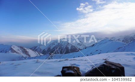 Ocean of clouds in snowy mountains at dawn 104539982