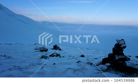 An ocean of clouds in the snowy mountains at dawn An ocean of clouds in the snowy mountains at dawn 104539986