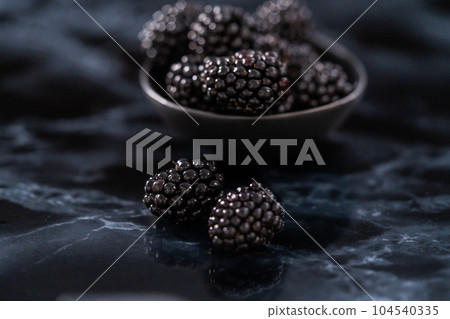 Fresh organic blackberries on ablack marble surface. Fresh organic blackberries on ablack marble surface. 104540335