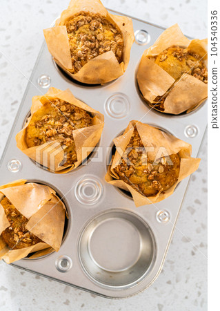 Freshly baked banana oatmeal muffins in a small muffin pan. Freshly baked banana oatmeal muffins in a small muffin pan. 104540336
