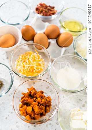 Measured ingredients in glass mixing bowls to make breakfast empanadas with eggs and sweet potato. Measured ingredients in glass mixing bowls to make breakfast empanadas with eggs and sweet potato. 104540417