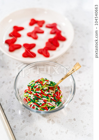 Measured ingredients in glass mixing bowls to make a chocolate pretzel Christmas wreath. 104540663