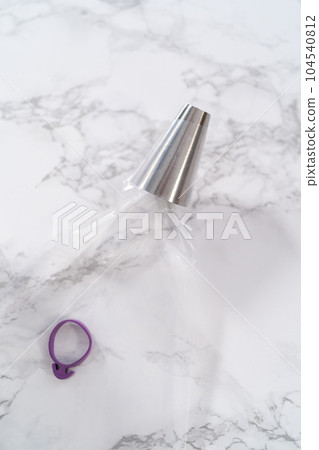 Filling piping bags with meringue to pipe Easter meringue cookies. Filling piping bags with meringue to pipe Easter meringue cookies. 104540812